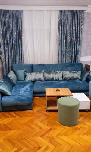un soggiorno con un divano blu e un tavolino da caffè di Central Apartment 