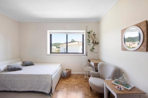 een slaapkamer met een bed, een bureau en een stoel bij Sobreiro22 in Lourosa