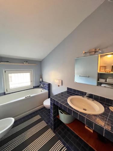 a bathroom with a tub and a sink and a bath tub at Casa all'Oca in Riva del Garda