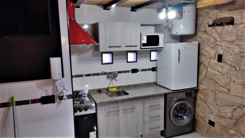 een kleine keuken met een koelkast en een wastafel bij ALQUILER POR DIA EN MALARGUE MUY CENTRICO in Malargüe