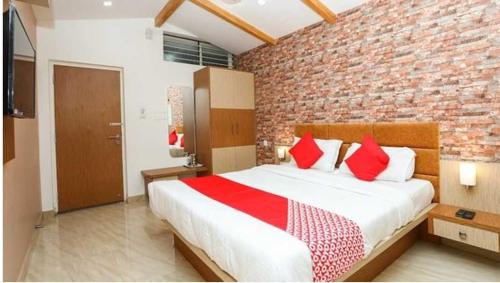 um quarto com uma cama grande e uma parede de tijolos em Flagship Sjr em Mysore