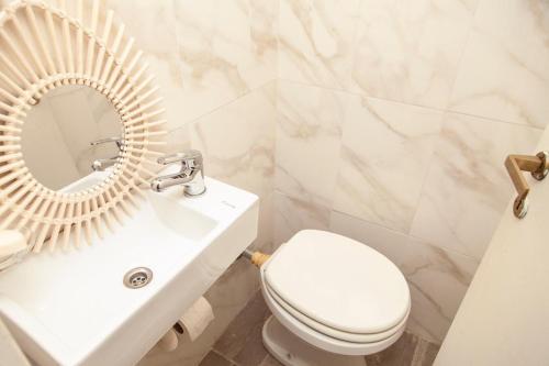 y baño con aseo blanco y espejo. en Excelente piso en el corazón de Palermo -5 PAX- en Buenos Aires