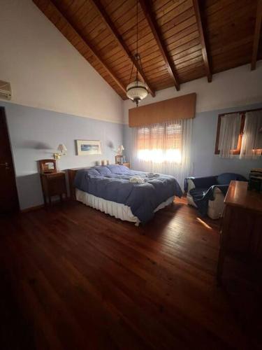 ein Schlafzimmer mit einem Bett in einem Zimmer mit Holzboden in der Unterkunft Hermosa casa en el corazón de Alta Córdoba in Cordoba