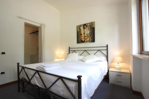 1 dormitorio con 1 cama con sábanas y almohadas blancas en Appia Antica 1BR with swimming pool en Roma
