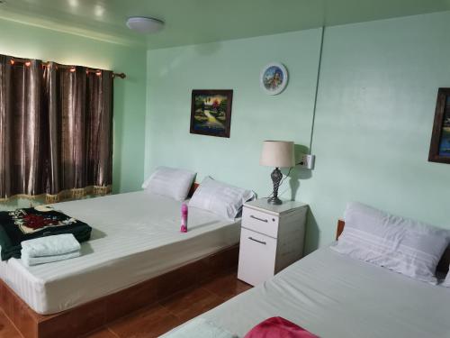 a bedroom with two beds and a lamp on a night stand at Bussaracum Resort in Kanchanaburi City