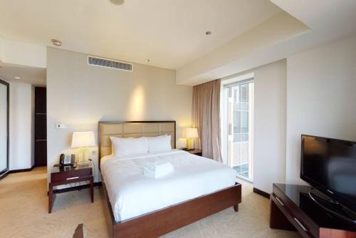 a bedroom with a bed and a flat screen tv at Key View - Emaar Residences, Marina Mall in Dubai