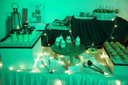 a table with a bunch of cupcakes on it with lights at Cherai Beach Palace in Cherai Beach