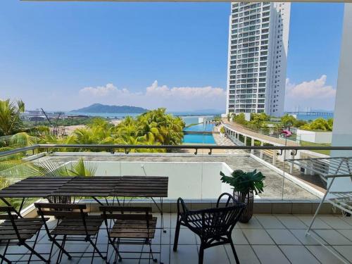 a balcony with a table and chairs on a building at Southbay Seaview Condo A10 #10minQueensbay #15minSPICE in Bayan Lepas