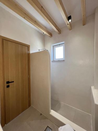 een badkamer met een koelkast en een raam bij Pefkos Blue in Pefki Rhodes