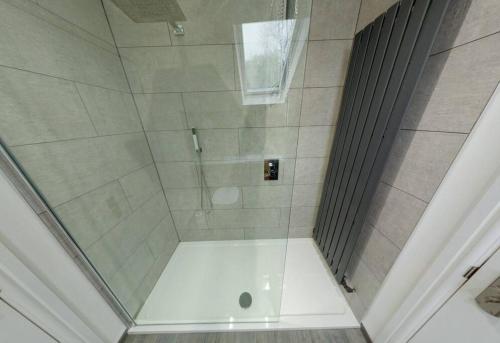 a shower with a glass door in a bathroom at The Coach House in Westoe