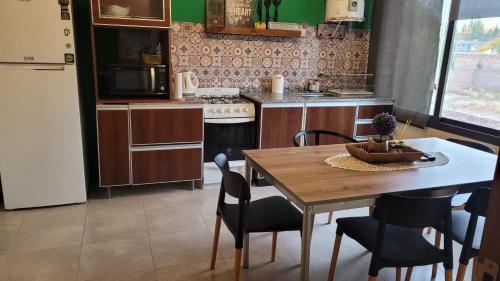 departamento confortable في سيوداد لوجان دي كويو: مطبخ مع طاولة وكراسي وثلاجة