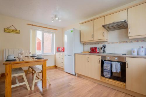 a kitchen with a wooden table and a counter top at Kirsty's Home Near Alton Towers in Rocester