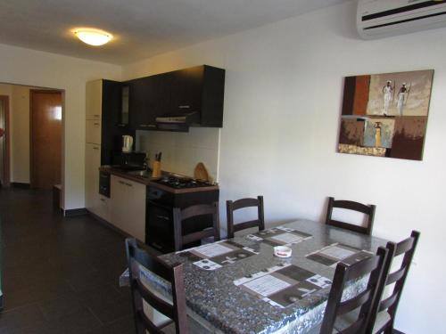 a kitchen with a table with chairs and a dining room at Apartment MiaAntonia in Vrsi