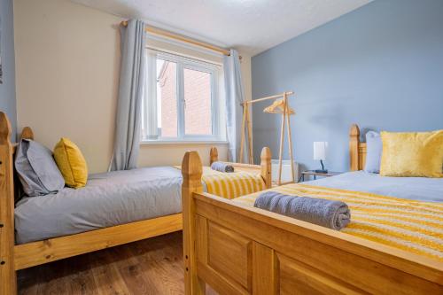 a bedroom with two beds and a window at Kirsty's Home Near Alton Towers in Rocester