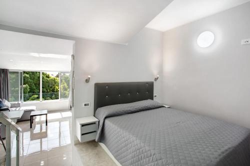 馬斯帕洛馬斯的住宿－Bungalow Mar Azul，一间卧室配有一张床、一张书桌和一个窗户。