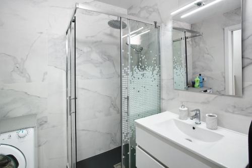 biała łazienka z prysznicem i umywalką w obiekcie Bungalow Mar Azul w mieście Maspalomas