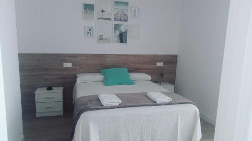 ein Schlafzimmer mit einem Bett mit einem grünen Kissen darauf in der Unterkunft Apartamento Suances in Suances