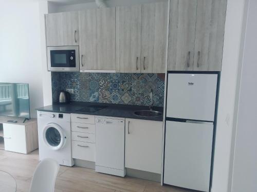 eine Küche mit einem Kühlschrank und einer Waschmaschine in der Unterkunft Apartamento Suances in Suances