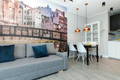 a living room with a couch and a dining room at Dream Team Nordic Haven in Bydgoszcz