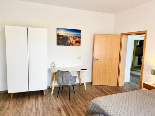 a bedroom with a desk and a bed at KrabatResidenz - Apartmenthaus in Burg