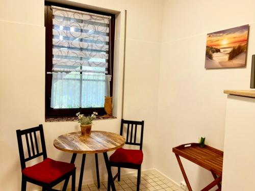 a table and chairs in a room with a window at KrabatResidenz - Apartmenthaus in Burg