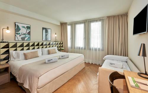 a hotel room with a large bed and a desk at The Moods Oasis in Barcelona