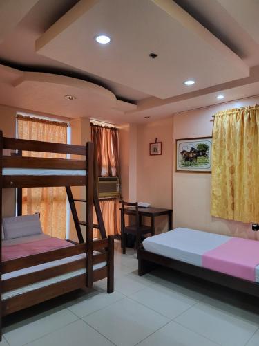 een slaapkamer met 2 stapelbedden en een bureau bij Rooms R Us - Voyagers Palace in Puerto Princesa City