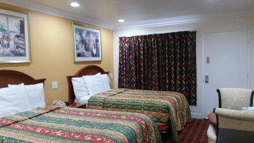 a hotel room with two beds and a window at Kona Inn Motel Anaheim in Anaheim