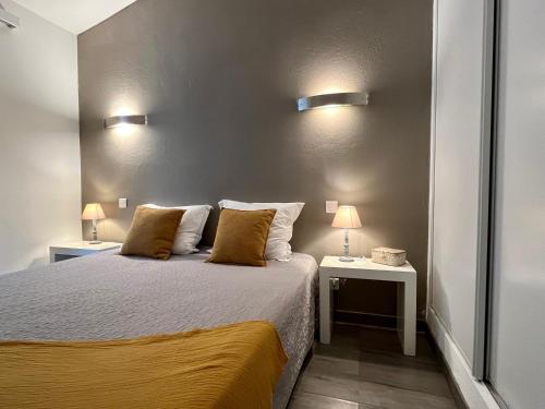 a bedroom with a bed with two tables and two lamps at Résidence Storia di Blue in Porto-Vecchio