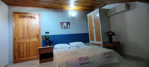 Schlafzimmer mit einem Bett und einer Holztür in der Unterkunft California Apart Otel in Oludeniz