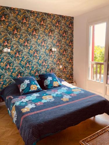 a bedroom with a bed with a floral wall at Maison piscine Bassin Arcachon in La Teste-de-Buch