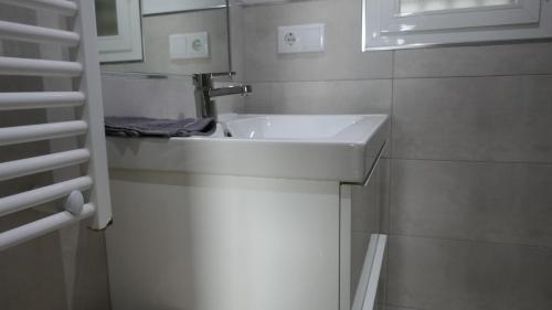 bagno con lavandino bianco e finestra di Vivienda Minca in La Herradura, Andalusien a La Herradura