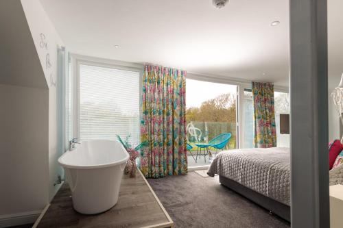 a bedroom with a tub and a bed and a window at Park Manor Hotel in Scarborough