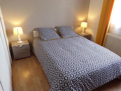 Un dormitorio con una cama con dos lámparas encima. en Chez Jeannette, en Lacanche