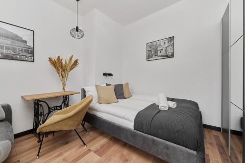 - une chambre avec un lit, une table et une chaise dans l'établissement Norwida Apartment with Balcony Downtown Wrocław by Renters, à Wrocław