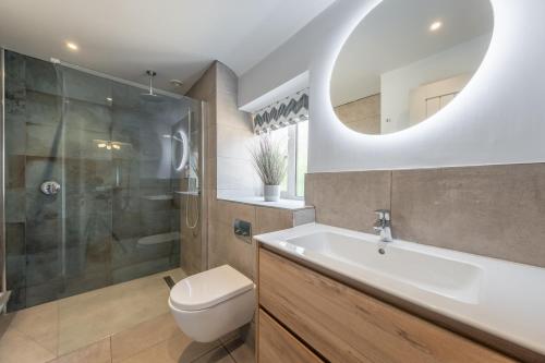 a bathroom with a sink toilet and a mirror at Castle Bungalow in Thornham