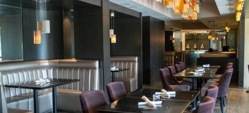 a restaurant with tables and chairs and a bar at The Mountaineer by InstantSuites Pool & HotTub in Canmore