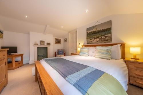 sypialnia z dużym łóżkiem i telewizorem w obiekcie Bluebell Cottage LW w mieście Little Walsingham