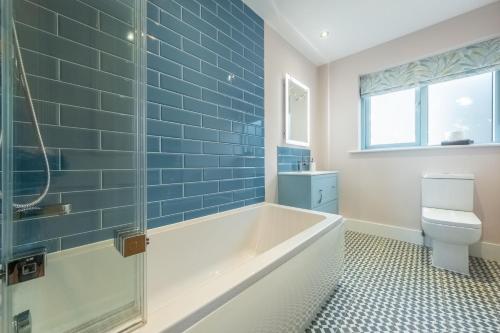 a bathroom with a tub and a toilet at Anchorage S in Salthouse