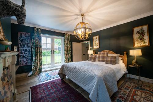um quarto com uma cama e um lustre em The Old Manor House em Brancaster