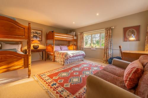 East Rudham的住宿－Garden Cottage ER，一间带两张双层床和一张沙发的卧室
