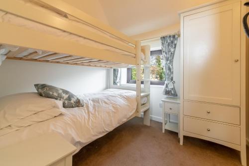 a bedroom with a bunk bed and a window at The Saltings Blakeney in Blakeney