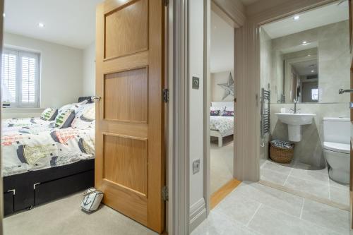 a bedroom with a bed and a bathroom at Tucked Away Cottage in Langham