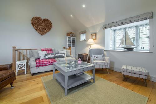 a living room with a couch and a table at Tucked Away Cottage in Langham