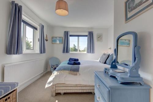 a bedroom with a bed with a blue dresser and a mirror at Egret in South Creake