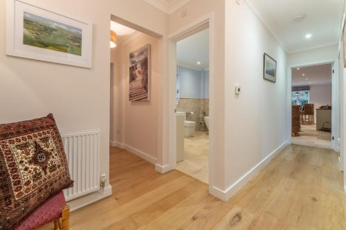 un corridoio con pareti bianche e pavimenti in legno in una casa di Waterside a Wiveton