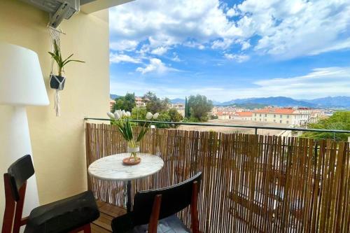 - un balcon avec une table et un vase de fleurs dans l'établissement Casamea - Studio, Parking, WiFi, Clim, Ajaccio, à Ajaccio