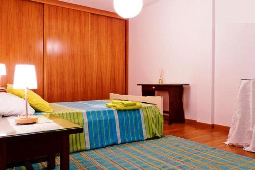 a bedroom with a bed with a desk and a table at Coloured Studio in Faro