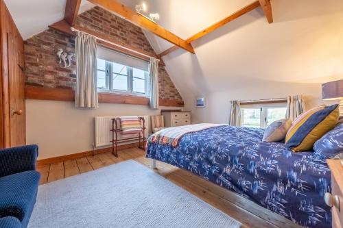 a bedroom with a bed and a window at Cornloft Cottage in South Creake