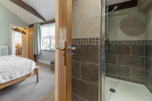 a bathroom with a shower and a bedroom with a bed at The Old Chapel W in Little Walsingham